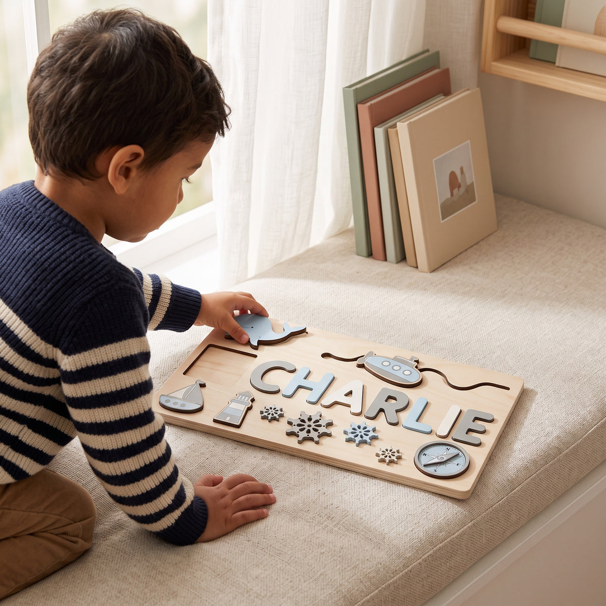 Toddler fitting the whale piece into the Momi Toys Personalized Wooden Name Puzzle, Ocean design