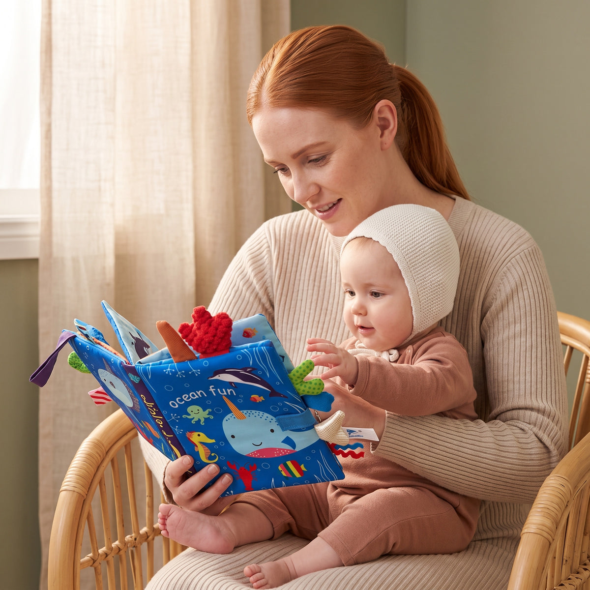 Mum reading the Momi Toys Soft Cloth Book, Ocean, to her baby