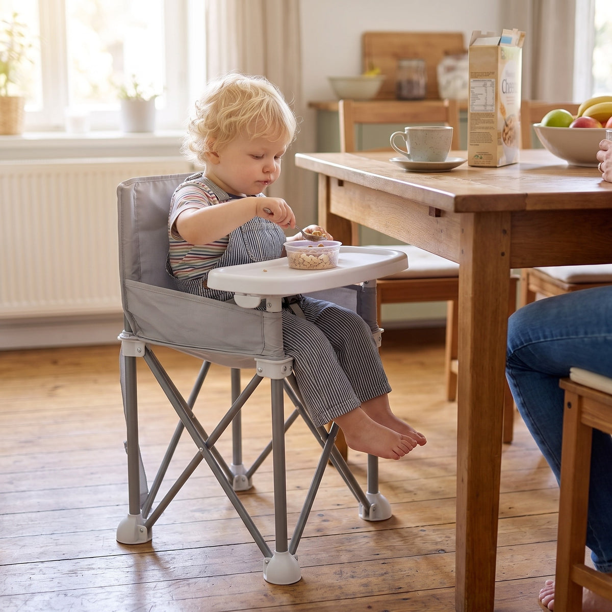 Momi Toys booster seat in a family kitchen at breakfast with a toddler eating from the tray