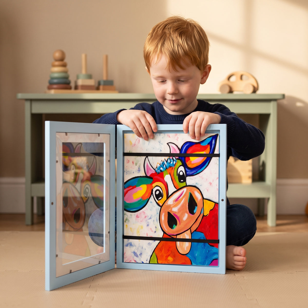 Boy filling the Momi Toys Kids Art Display Frame, blue