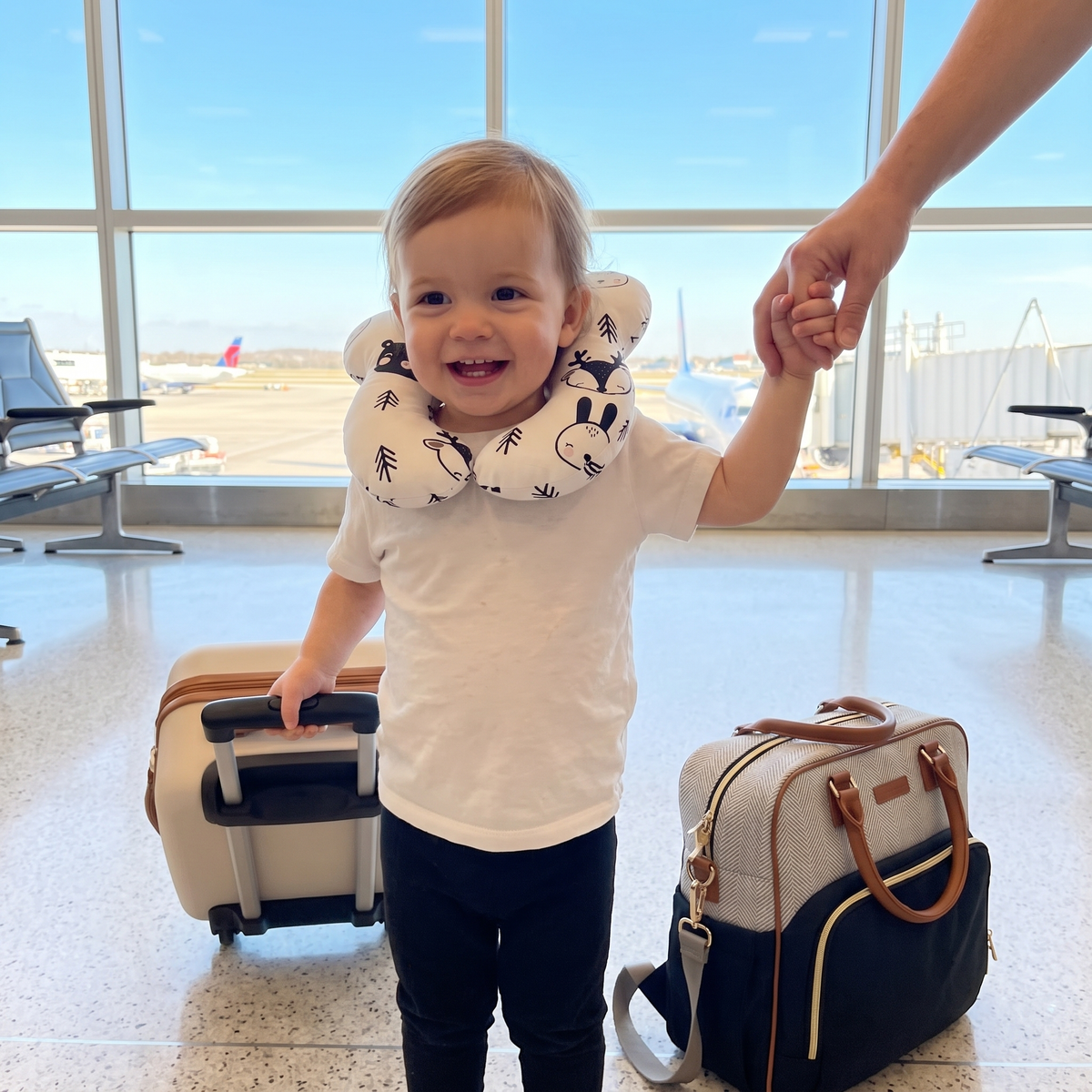 Child wearing travel pillow at airport with family luggage