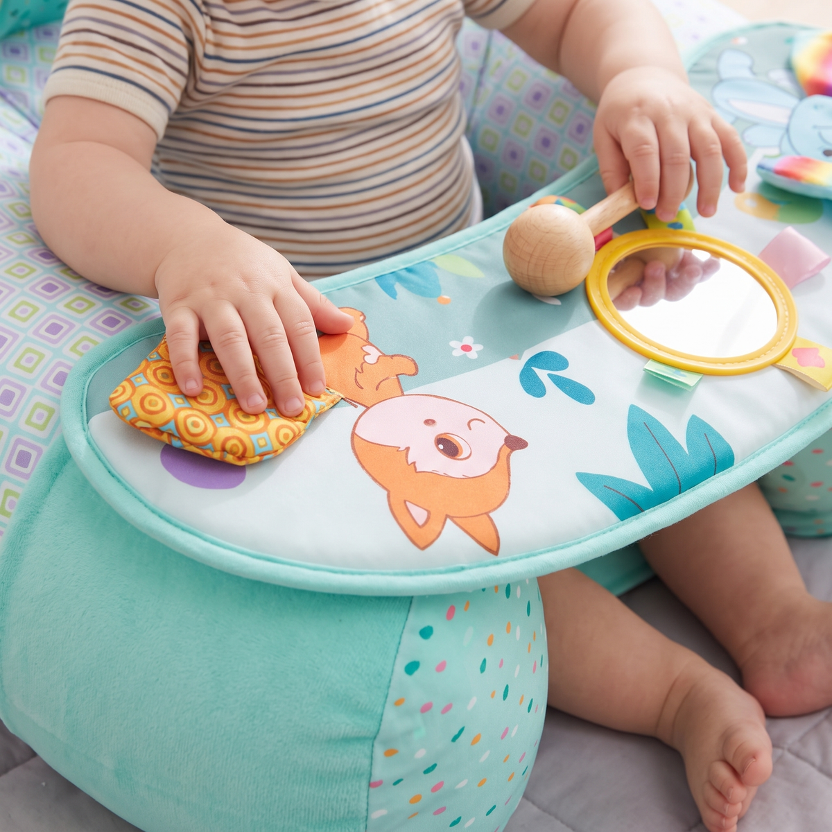 Close up of floor seat play tray with mirror and soft toys