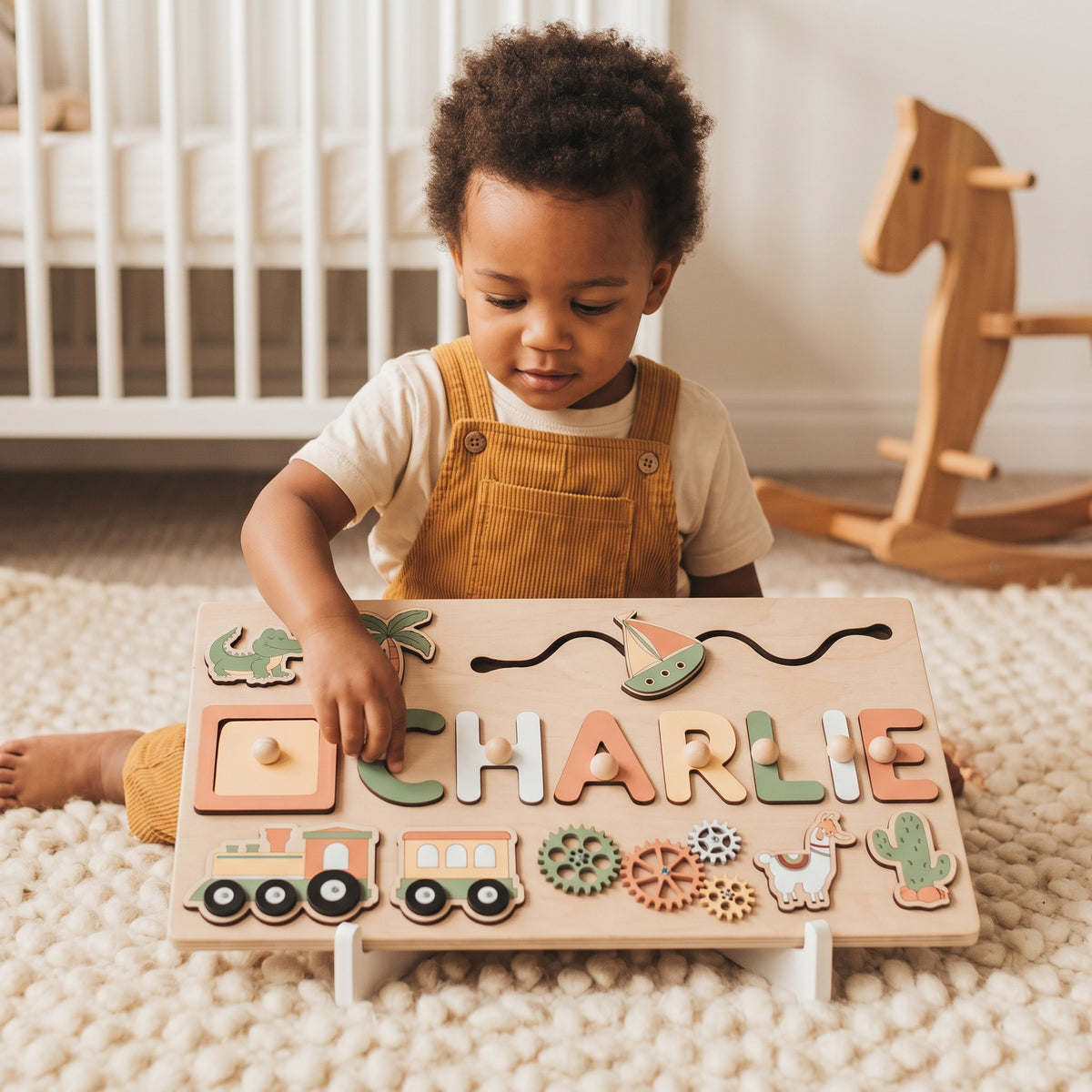 Toddler placing a letter into the Momi Toys Personalized Wooden Name Puzzle, Adventure design