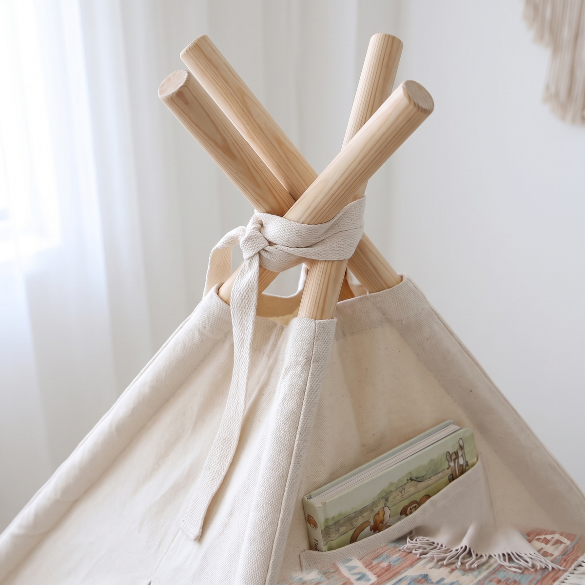 Close up of pine poles and cotton canvas at teepee top