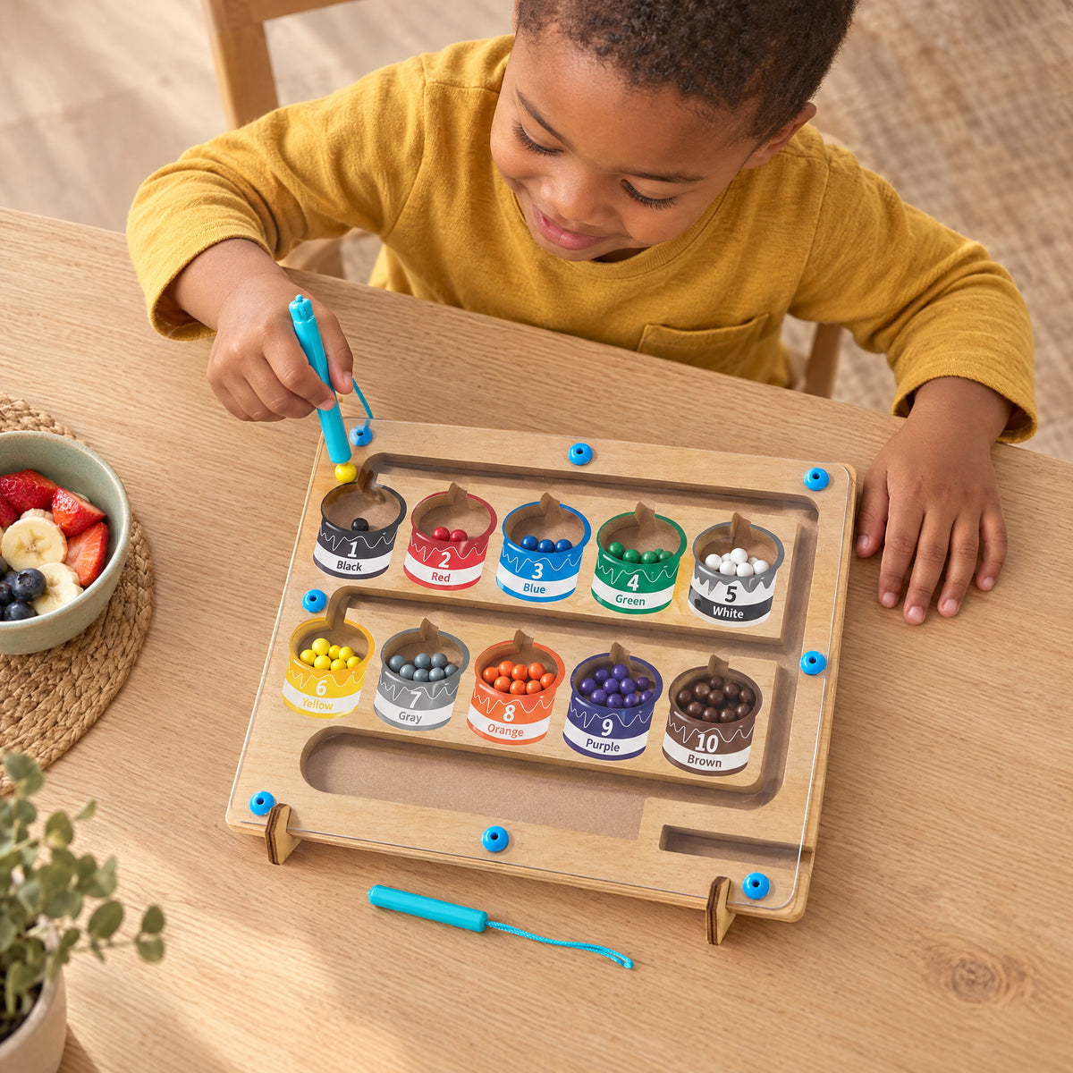 Child playing with the Momi Toys magnetic bead maze board lifestyle photo